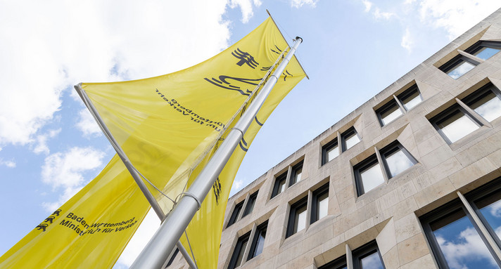 Fahnen wehen vor einem Gebäude.