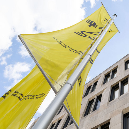 Fahnen wehen vor einem Gebäude.